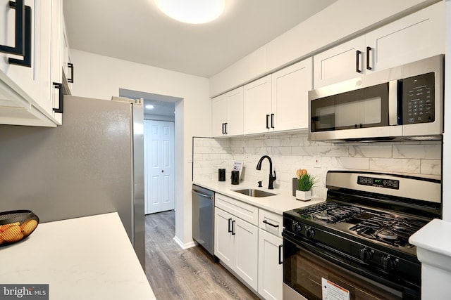 kitchen with decorative backsplash, stainless steel appliances, sink, dark hardwood / wood-style floors, and white cabinetry