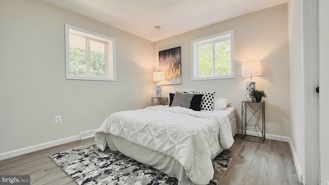 bedroom featuring light hardwood / wood-style flooring and multiple windows