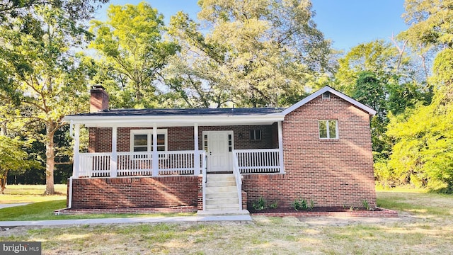 view of front of house featuring covered porch and a front lawn