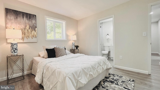 bedroom featuring ensuite bath and hardwood / wood-style flooring