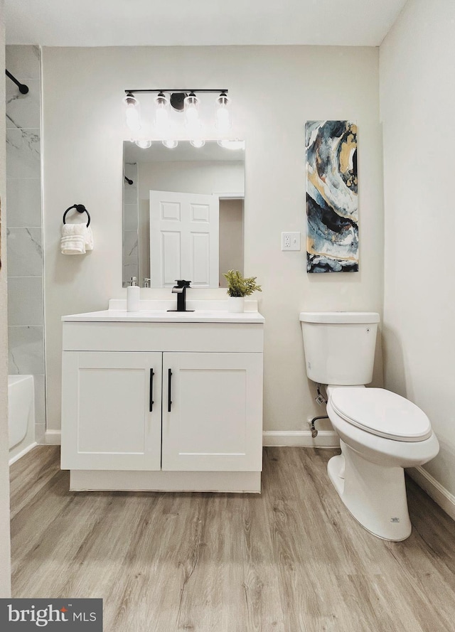 full bathroom featuring toilet, bathing tub / shower combination, vanity, and hardwood / wood-style flooring