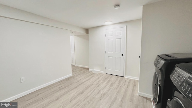 washroom featuring washing machine and clothes dryer and light hardwood / wood-style flooring