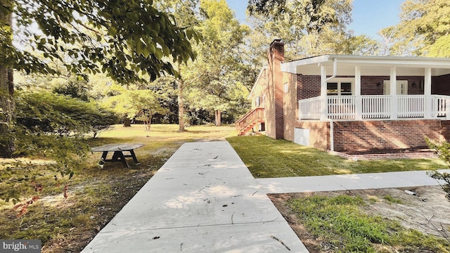 view of side of home with a porch and a lawn