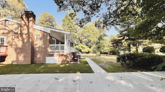 view of side of home with a yard