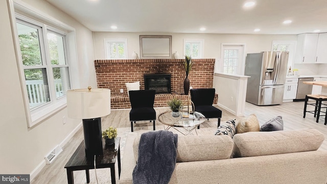 living room with a fireplace and light hardwood / wood-style flooring