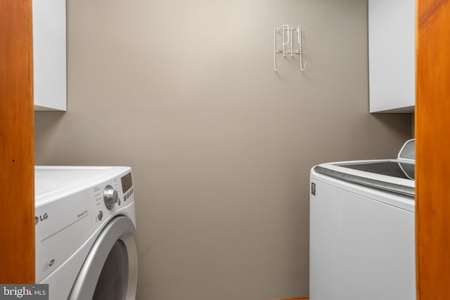 laundry room featuring cabinets and washing machine and clothes dryer