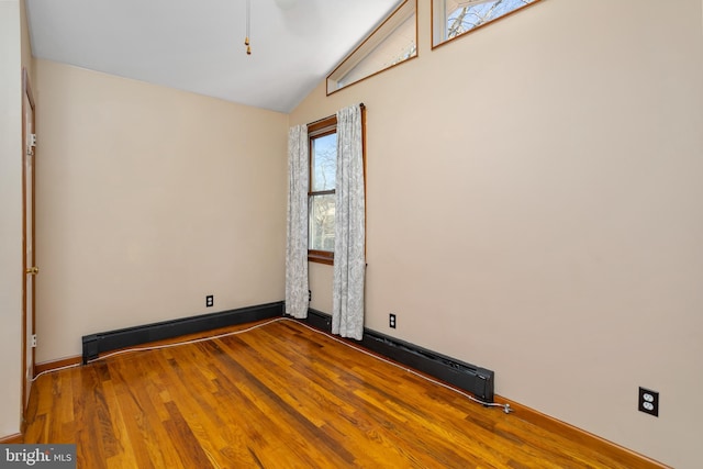 spare room featuring hardwood / wood-style floors and lofted ceiling