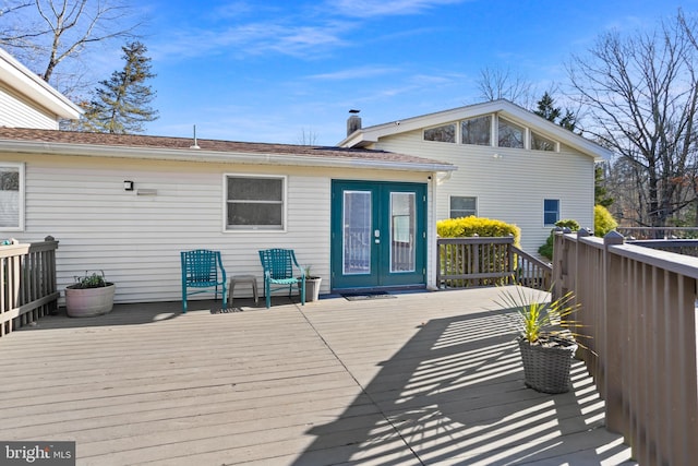 rear view of house with a wooden deck and french doors