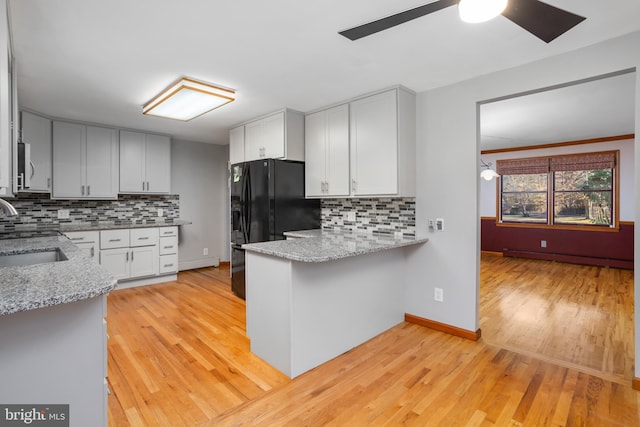 kitchen with tasteful backsplash, white cabinetry, sink, and a baseboard heating unit