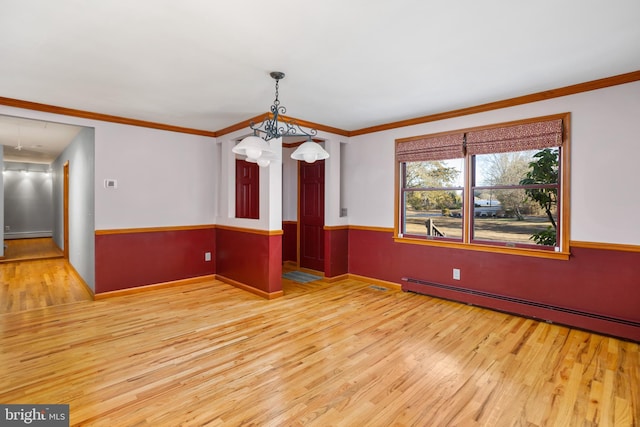 unfurnished dining area featuring hardwood / wood-style floors, a chandelier, crown molding, and a baseboard heating unit