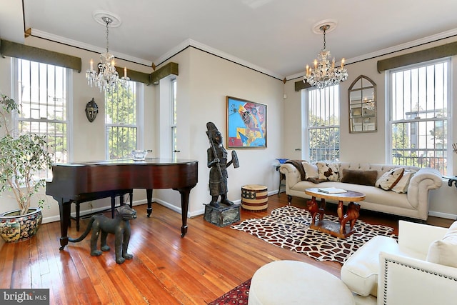 living room with a chandelier, a healthy amount of sunlight, and crown molding