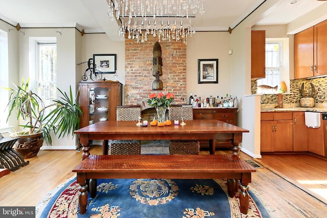 dining space with light wood-type flooring and crown molding