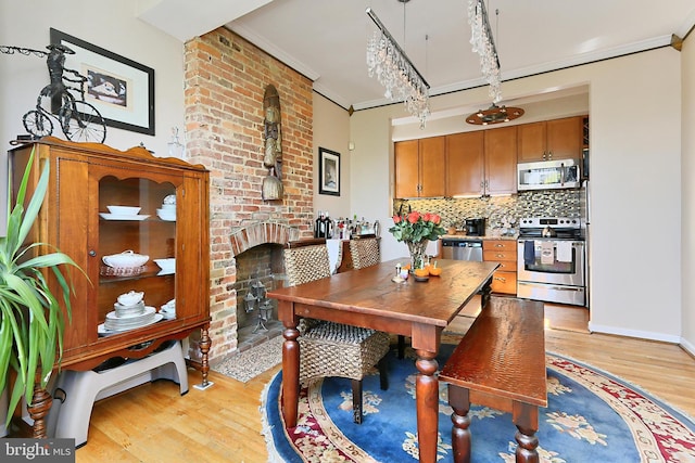 dining room featuring light hardwood / wood-style flooring, ornamental molding, and a notable chandelier