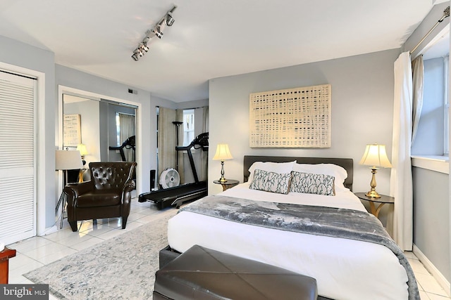 bedroom with rail lighting and light tile patterned flooring