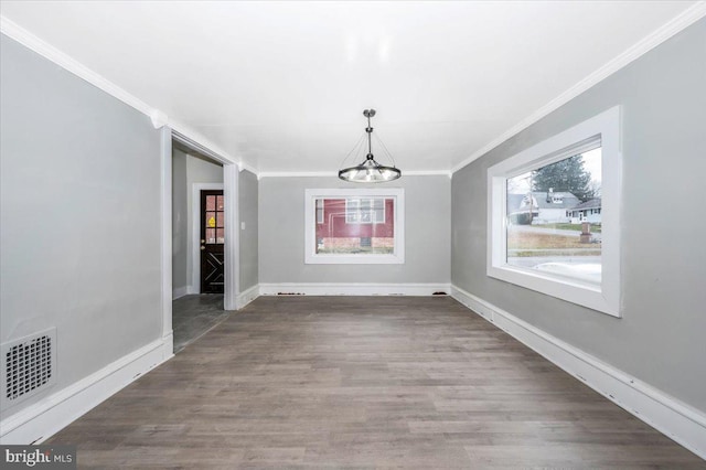 unfurnished dining area with a chandelier, hardwood / wood-style flooring, and ornamental molding