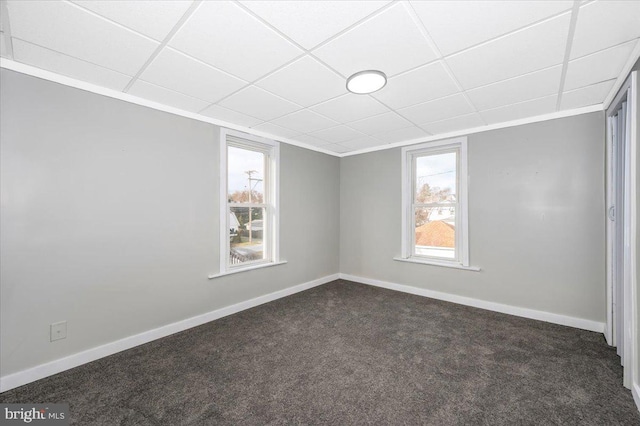 carpeted spare room with a paneled ceiling
