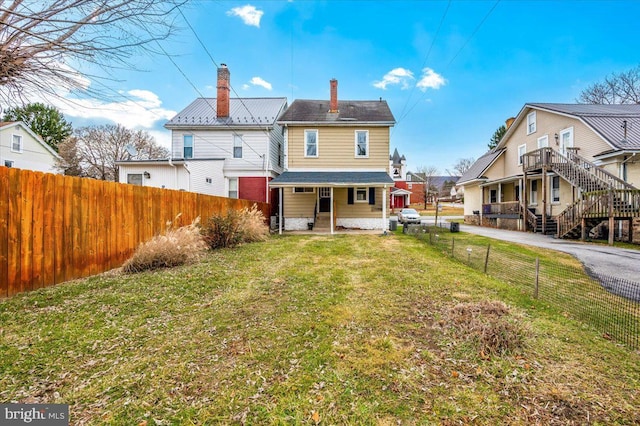 back of house featuring a lawn