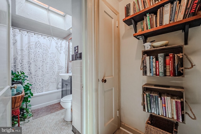 bathroom with shower / bath combination with curtain and toilet