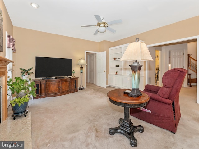 living room with ceiling fan, a fireplace, and carpet