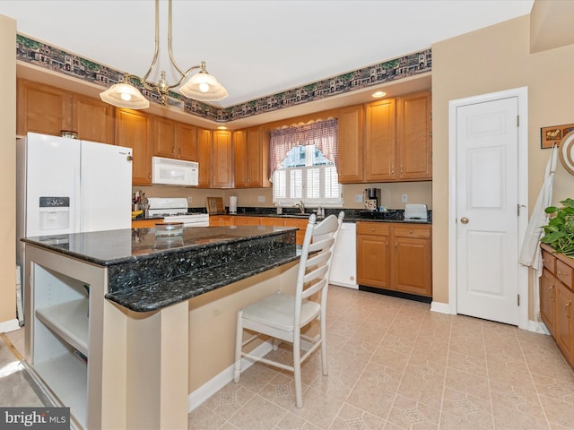 kitchen featuring a kitchen island, pendant lighting, sink, dark stone countertops, and white appliances