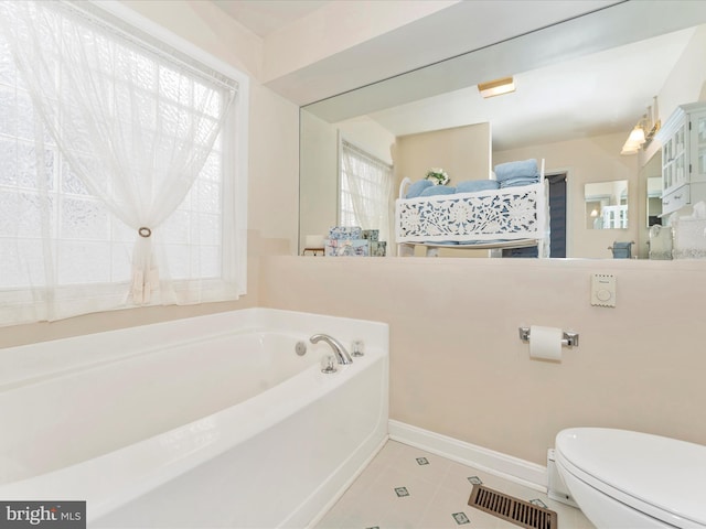 bathroom with toilet, tile patterned flooring, and a bathtub