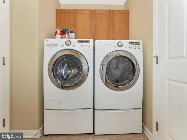 laundry area with cabinets, separate washer and dryer, and light tile patterned floors