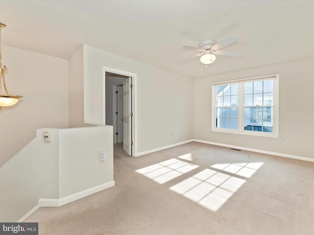 carpeted spare room featuring ceiling fan