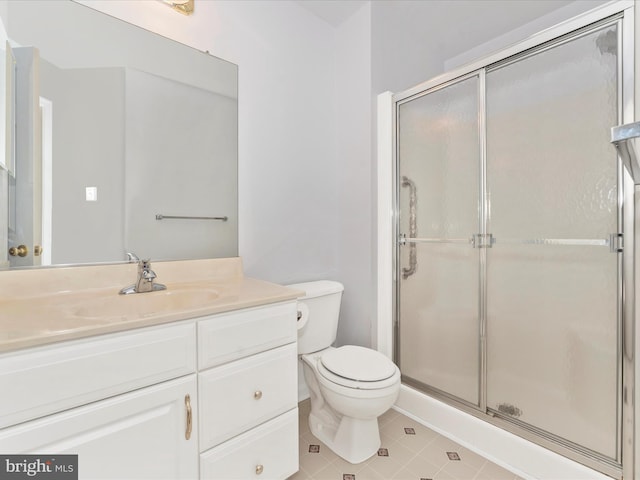 bathroom featuring vanity, tile patterned flooring, a shower with shower door, and toilet