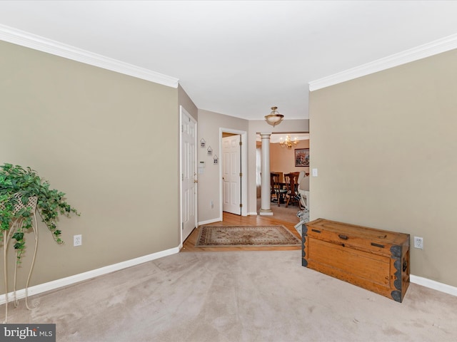 entryway with decorative columns, crown molding, light colored carpet, and an inviting chandelier