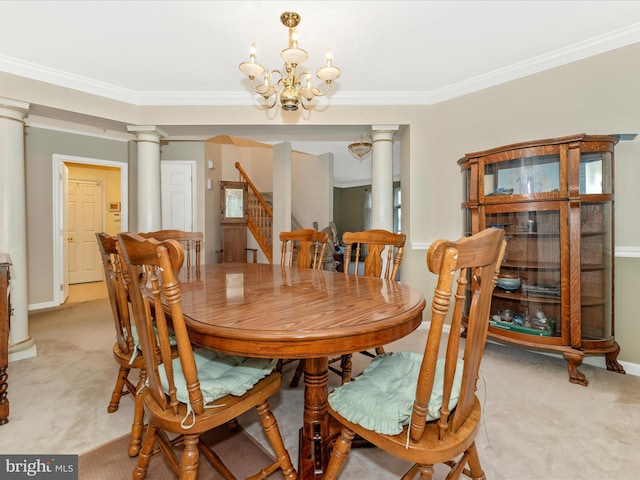 carpeted dining area with decorative columns, crown molding, and a chandelier