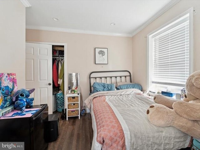 bedroom featuring dark hardwood / wood-style floors, ornamental molding, and a closet