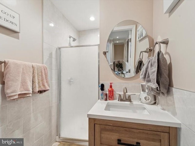 bathroom with a shower with door and vanity