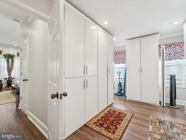 hallway with crown molding and hardwood / wood-style floors