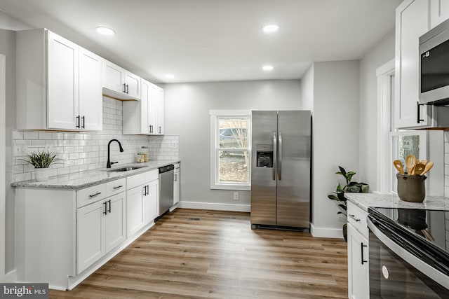 kitchen featuring appliances with stainless steel finishes, white cabinetry, and sink