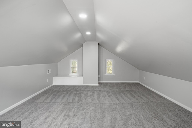 additional living space with vaulted ceiling and light colored carpet