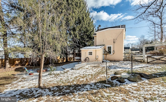 view of snow covered rear of property