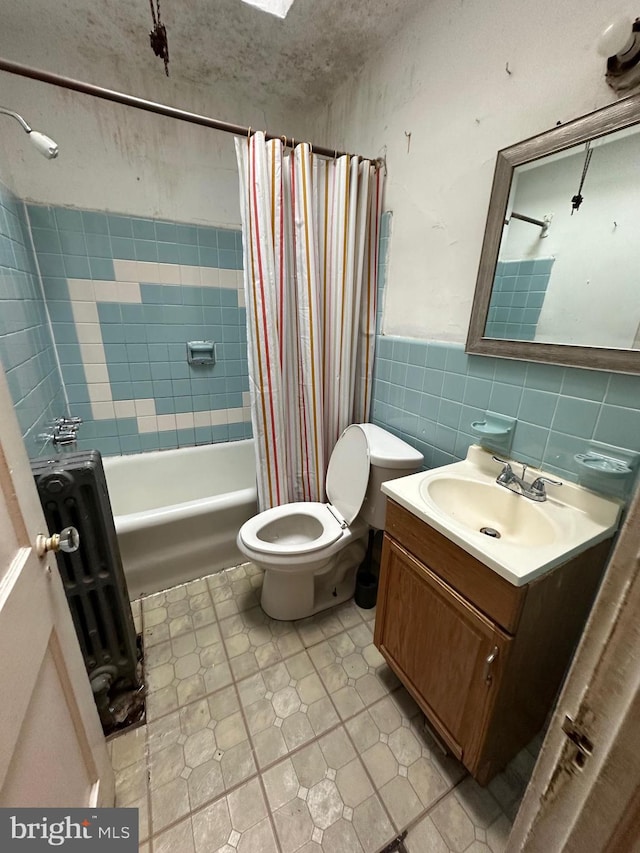 full bathroom featuring shower / bathtub combination with curtain, a textured ceiling, toilet, vanity, and tile walls