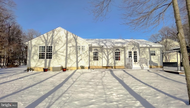 view of snow covered back of property