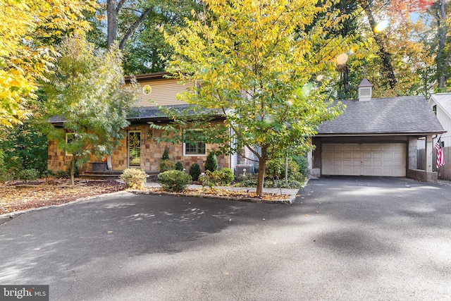 view of front of property featuring central AC unit and a garage