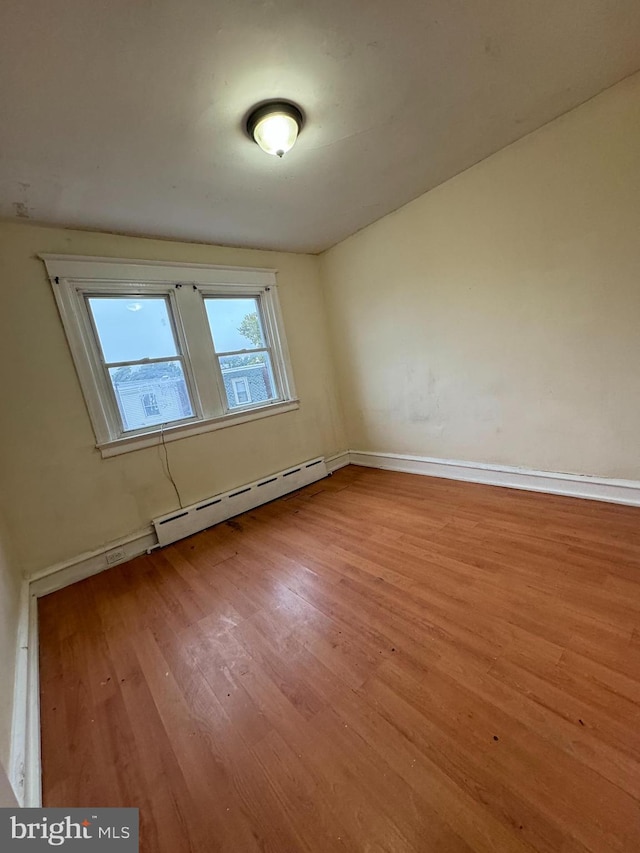 spare room featuring light hardwood / wood-style floors and a baseboard heating unit