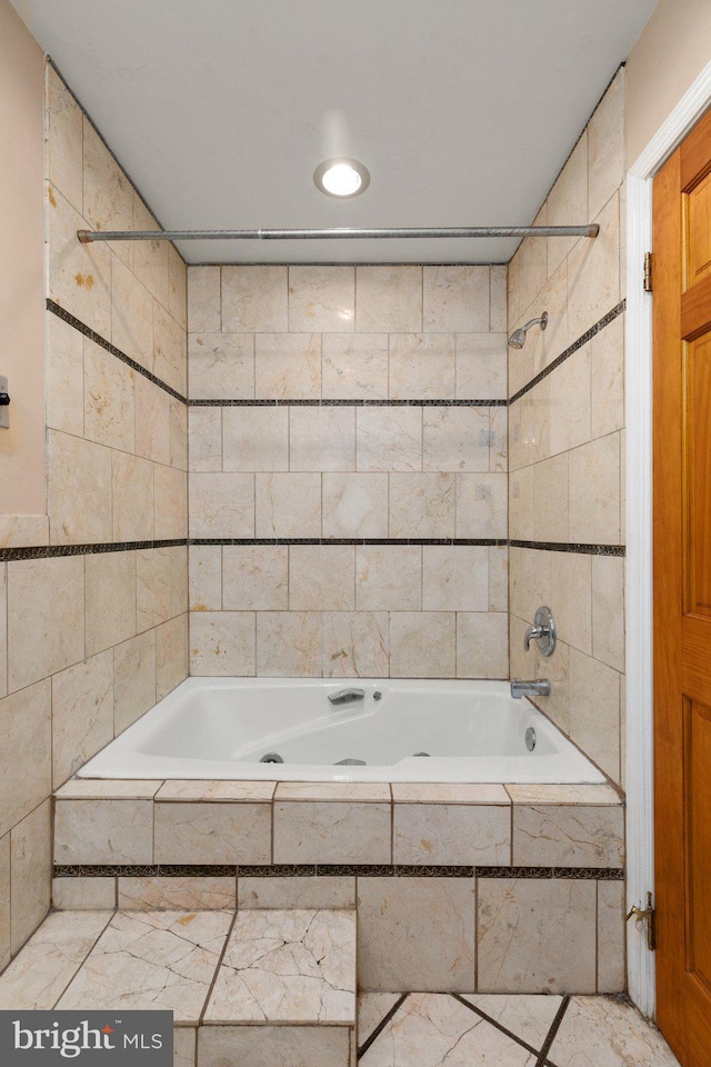 bathroom with tiled shower / bath combo and tile walls