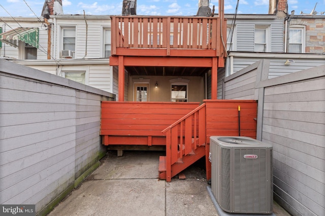 rear view of property with central AC and a balcony