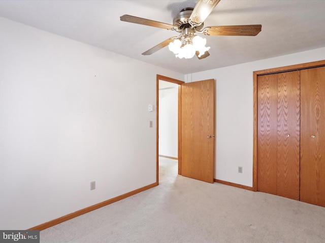 unfurnished bedroom featuring light colored carpet, ceiling fan, and a closet