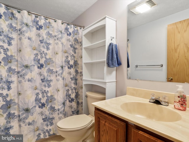 bathroom with vanity, toilet, curtained shower, and a textured ceiling