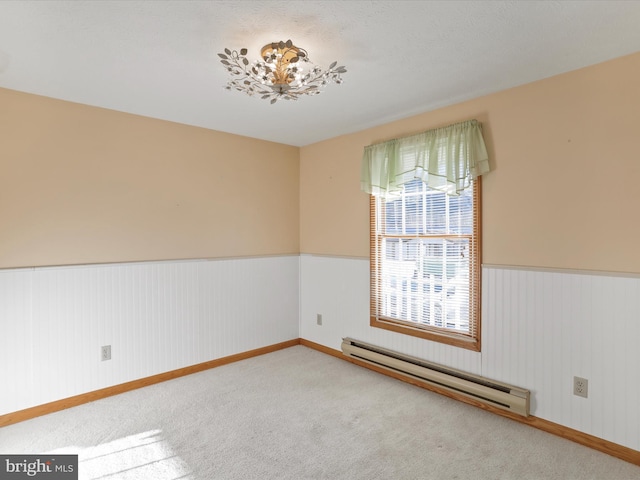 carpeted empty room featuring baseboard heating