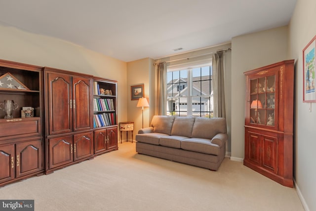 living area featuring light carpet