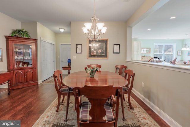 dining area featuring a notable chandelier and dark hardwood / wood-style flooring