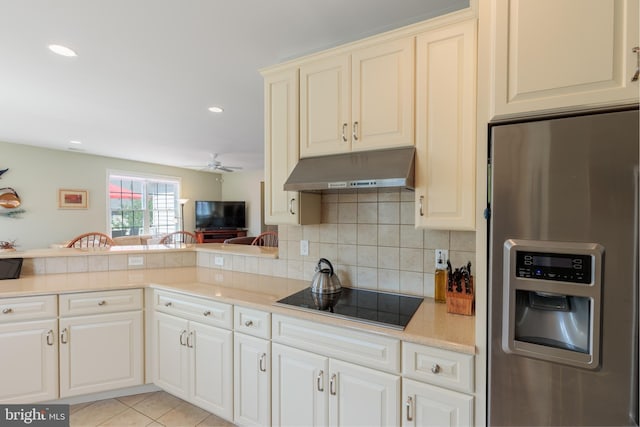 kitchen with light tile patterned floors, ceiling fan, stainless steel refrigerator with ice dispenser, tasteful backsplash, and black electric stovetop