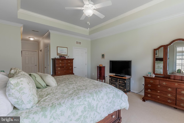 bedroom featuring crown molding, a tray ceiling, light carpet, and a closet