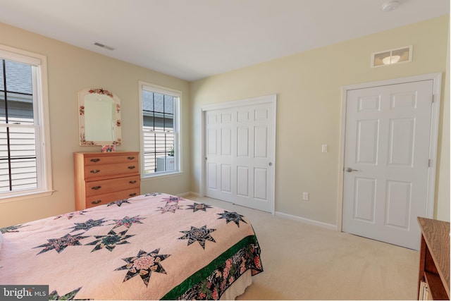 bedroom featuring light colored carpet and a closet